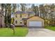 Charming yellow two-story home with a well-manicured lawn and attached garage, perfect for Gathering living at 3845 Springleaf Ct, Stone Mountain, GA 30083