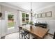 Charming dining area with rustic wood table, black chairs, wainscoting, and natural light from the backyard at 4371 Wigley Preserve Dr, Marietta, GA 30066