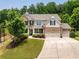 Charming two-story brick home featuring a three-car garage and lush landscaping at 4371 Wigley Preserve Dr, Marietta, GA 30066