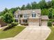 Charming two-story brick home featuring a three-car garage and lush landscaping at 4371 Wigley Preserve Dr, Marietta, GA 30066