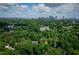 Aerial view of a lush neighborhood with mature trees and the city skyline in the background at 936 Ormewood Se Ter, Atlanta, GA 30316