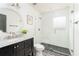 Stylish bathroom features a glass-enclosed shower, patterned tile floor, and sleek vanity with marble countertop at 936 Ormewood Se Ter, Atlanta, GA 30316