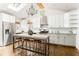 Bright kitchen features an island with seating, white cabinets, stainless steel appliances, and modern lighting at 936 Ormewood Se Ter, Atlanta, GA 30316