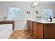 Bathroom featuring a double sink vanity, large mirror, and a view of the backyard through the window at 1233 Miss Irene Ln, Lawrenceville, GA 30044