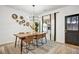 A modern dining room featuring a wood table, six chairs, and an eye-catching light fixture at 1233 Miss Irene Ln, Lawrenceville, GA 30044