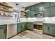 Well-lit kitchen showcasing sage green cabinets, stainless steel appliances, and subway tile backsplash at 1233 Miss Irene Ln, Lawrenceville, GA 30044