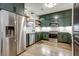 Bright kitchen with sage green cabinets, open shelving, stainless steel appliances, and light wood floors at 1233 Miss Irene Ln, Lawrenceville, GA 30044