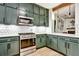 Modern kitchen featuring stainless steel appliances, white subway tile backsplash, and sage green cabinets at 1233 Miss Irene Ln, Lawrenceville, GA 30044