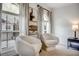 Sitting area with two modern cocoon chairs next to a black side table and large picture windows at 1233 Miss Irene Ln, Lawrenceville, GA 30044