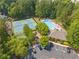 An aerial view of tennis courts and a swimming pool surrounded by lush greenery, playground, and trees at 139 Mountain Vista Blvd, Canton, GA 30115