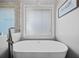 Bright bathroom with a soaking tub and a large window at 139 Mountain Vista Blvd, Canton, GA 30115