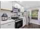 Bright kitchenette with stainless steel appliances and white cabinets, offering a clean and efficient space at 139 Mountain Vista Blvd, Canton, GA 30115