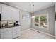 Cozy kitchenette with white cabinets, granite countertops, and bright natural light from the window at 139 Mountain Vista Blvd, Canton, GA 30115