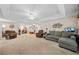 Spacious living room with plush carpeting, tray ceiling, fan, modern furniture, and a wall-mounted television at 139 Mountain Vista Blvd, Canton, GA 30115
