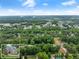 Expansive aerial shot of a property nestled within a lush, green landscape under a blue sky at 1920 Pilgrim Rd, Cumming, GA 30040