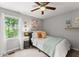 Bedroom featuring neutral tones, wood accents, and a sun-filled window at 1920 Pilgrim Rd, Cumming, GA 30040