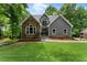 Charming home featuring stone accents, gray siding, and a beautifully landscaped front yard at 1920 Pilgrim Rd, Cumming, GA 30040