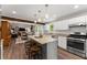 A kitchen with white cabinets, granite countertops and a grey kitchen island with seating at 1920 Pilgrim Rd, Cumming, GA 30040