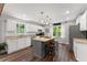 A kitchen with white cabinets, granite countertops and a grey kitchen island with seating at 1920 Pilgrim Rd, Cumming, GA 30040