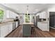 A kitchen with white cabinets, granite countertops and a grey kitchen island with seating at 1920 Pilgrim Rd, Cumming, GA 30040