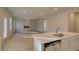 Open concept kitchen with an island, sink, and stainless steel appliances, seamlessly connected to the living room at 2525 Dixon Pl, Lawrenceville, GA 30045