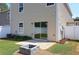 Backyard featuring a patio, stone firepit, green grass, and a white vinyl fence for privacy at 5465 Mountain Top Pl, Cumming, GA 30041