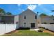 A fenced in backyard, with green grass, a stone fire pit, and a sliding door to enter the home at 5465 Mountain Top Pl, Cumming, GA 30041