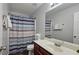 Well-lit bathroom features a vanity with a sleek countertop, a framed mirror, and a shower with a curtain at 5465 Mountain Top Pl, Cumming, GA 30041