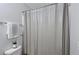This bathroom has a shower with curtain, gray walls, and toilet with towels and decorative plant at 5465 Mountain Top Pl, Cumming, GA 30041