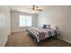 Bedroom featuring a ceiling fan, neutral carpet, and a bright window for natural lighting at 5465 Mountain Top Pl, Cumming, GA 30041