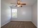 A bedroom with a carpeted floor, gray walls, a window, and a ceiling fan with a lighting fixture at 5465 Mountain Top Pl, Cumming, GA 30041