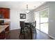 Dining area with sliding glass doors to the backyard, dark wood table, and view into the kitchen at 5465 Mountain Top Pl, Cumming, GA 30041