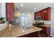 Modern kitchen with granite countertops, stainless steel sink, and dark wood cabinetry at 5465 Mountain Top Pl, Cumming, GA 30041
