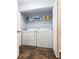Convenient laundry closet with a washer, dryer, and shelving for supplies and organization at 5465 Mountain Top Pl, Cumming, GA 30041