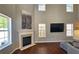 Elegant living room featuring a fireplace, hardwood floors, and natural light from multiple windows at 5465 Mountain Top Pl, Cumming, GA 30041