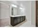 Bathroom includes a double sink vanity with dark wood cabinets and a large mirror at 1360 Sugar Glen Ct, Lawrenceville, GA 30044