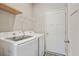 Bright laundry room includes new washer, dryer, and white storage shelves at 1360 Sugar Glen Ct, Lawrenceville, GA 30044