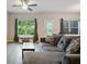 Comfortable living room with gray sectional sofa, large windows, and ceiling fan at 1360 Sugar Glen Ct, Lawrenceville, GA 30044