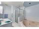 Light and airy bathroom with blue walls, tiled shower, and large soaking tub beneath a modern lighting fixture at 4544 Ridgeview Dr, Powder Springs, GA 30127