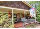 Inviting covered front porch with seating area, red shutters, and a brick facade at 4544 Ridgeview Dr, Powder Springs, GA 30127