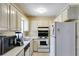 Functional kitchen with white cabinets, black appliances, and ample counter space at 4544 Ridgeview Dr, Powder Springs, GA 30127