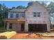 New construction two-story home featuring an attached two-car garage and a covered front porch at 5371 Heron Bay Blvd, Locust Grove, GA 30248
