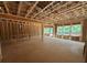 Unfinished living room showcasing the stud framing and the planned spacious layout with natural light at 5371 Heron Bay Blvd, Locust Grove, GA 30248