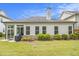 A well-kept backyard with an outdoor grill, sunroom, manicured landscaping and a view of the home's exterior at 11375 Crestview Ter, Johns Creek, GA 30024