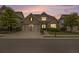 Charming brick home with a two-car garage, lush landscaping under dramatic twilight sky at 11375 Crestview Ter, Johns Creek, GA 30024