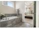 A luxurious garden tub is tiled with a stylish stone pattern at 11375 Crestview Ter, Johns Creek, GA 30024