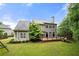 Exterior view of the home's rear facade, showcasing a beautiful deck, lush lawn, and mature landscaping at 2301 Kirk Farm Nw Pl, Kennesaw, GA 30152