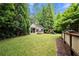 Lush backyard featuring a well-maintained lawn, mature trees, and a charming playset at 2301 Kirk Farm Nw Pl, Kennesaw, GA 30152