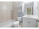 Bright bathroom features a tub, tile surround, vanity with storage, and neutral colors at 2301 Kirk Farm Nw Pl, Kennesaw, GA 30152