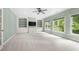 Spacious living room with built-in shelving, a ceiling fan, and large windows overlooking the backyard at 2301 Kirk Farm Nw Pl, Kennesaw, GA 30152